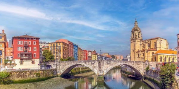 Vue panoramique d'une ville historique avec pont en pierre, idéale pour un séjour avec hôtel petit déjeuner inclus.