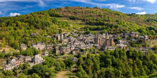 Vue sur le village de Conques en Occitanie, destination prisée proposant des services d'hôtel petit déjeuner authentiques.